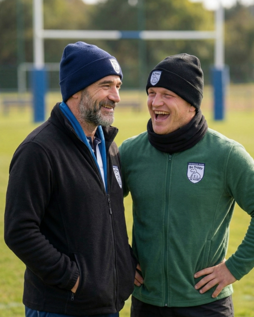 deux hommes rugby amateur bonnet bord terrain discutant match hiver