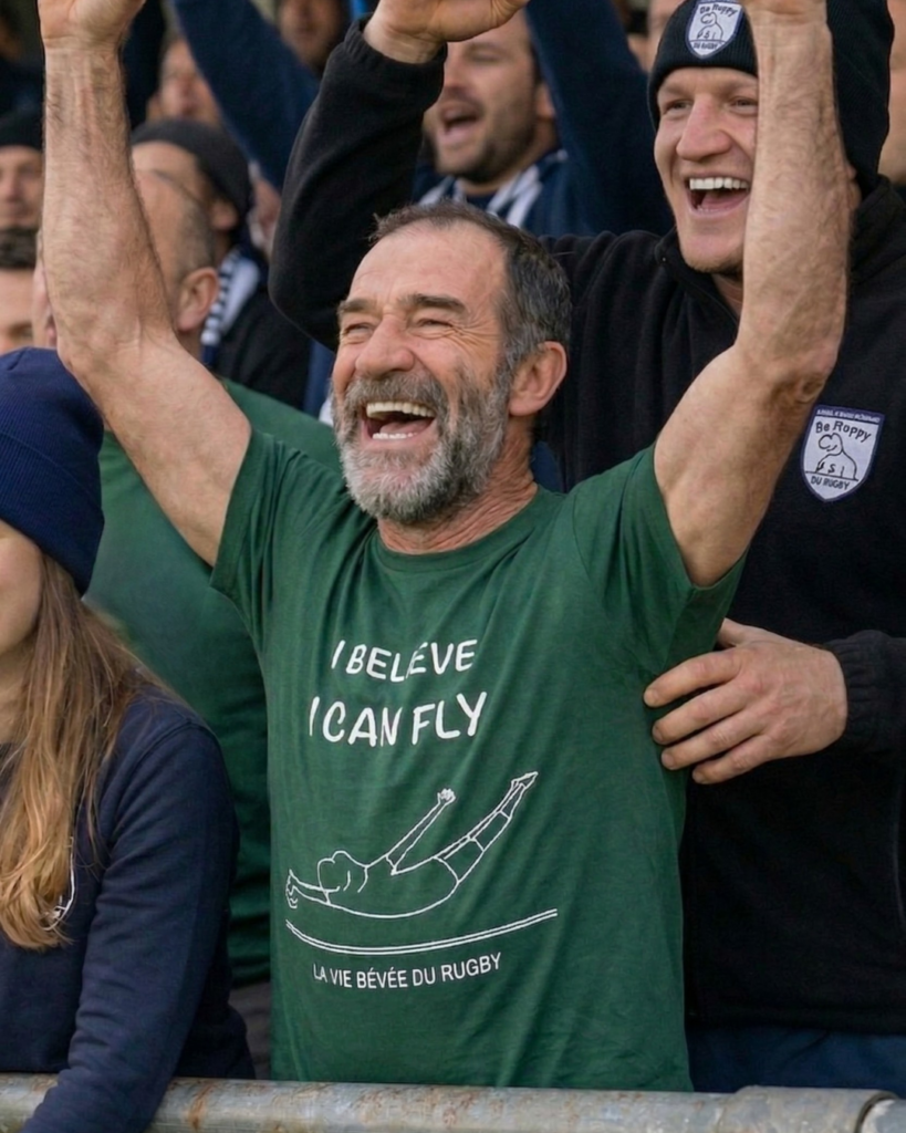 Supporter de rugby amateur en tribune portant un tee-shirt I believe I can fly lors d’un match